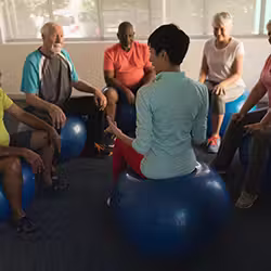 female-trainer-training-senior-people-performing-exercise